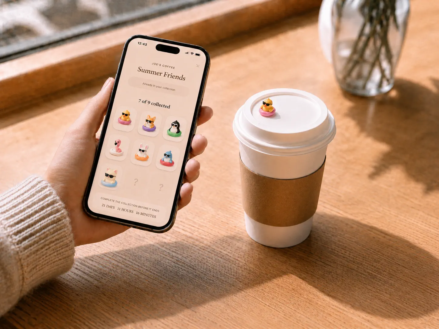 Guest holding a phone showing their collection next to a coffee cup with a collectible figure